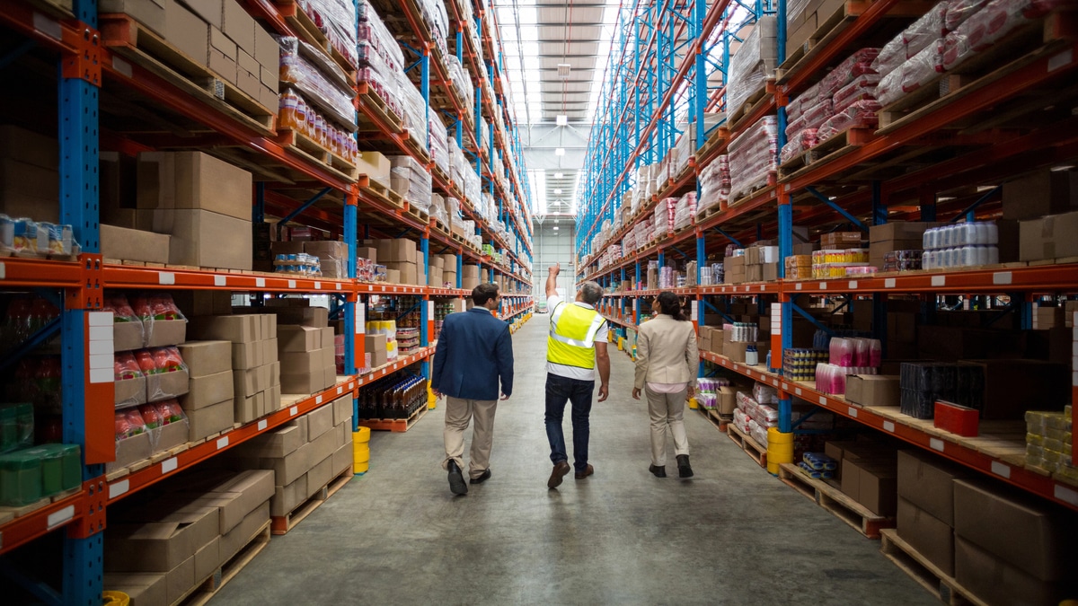 Best Practices for Warehouse & Distribution Center Security Team inspects towering shelves in a bustling warehouse.