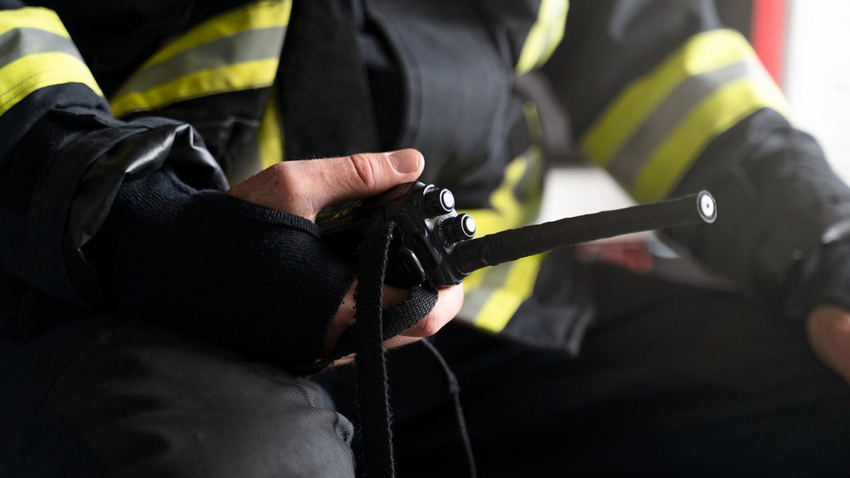 How-Fire-Watch-Security-Works-&-When-You-Need-It Firefighter holding a walkie-talkie, safety gear visible.
