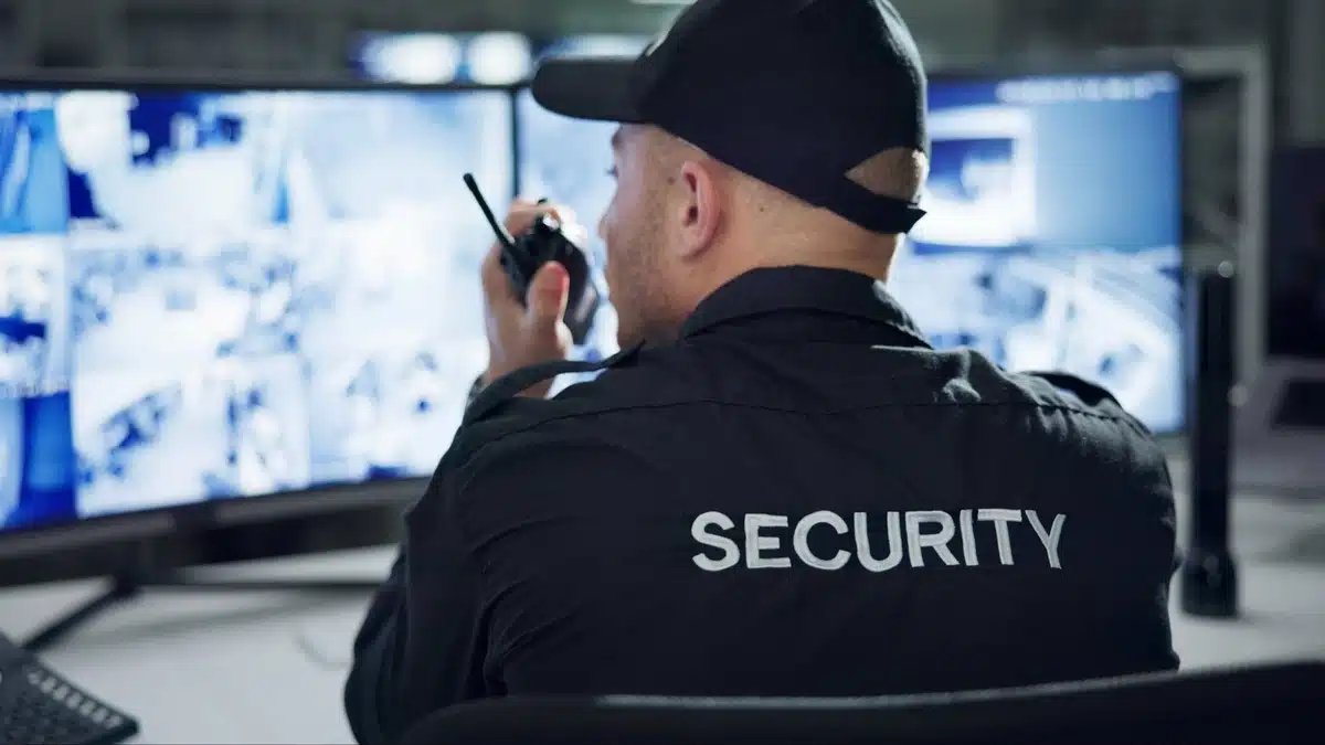How to Choose the Right Security Company in Dallas A Complete Checklist “Choosing the Right Security Company in Dallas: A Complete Checklist – A security guard oversees multiple surveillance monitors inside a control room.”