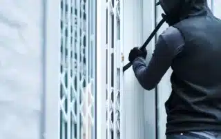 “How to Reduce Theft on Commercial Properties Quickly – An intruder uses a crowbar while attempting to break into a building.”