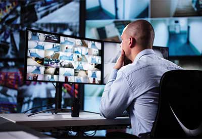 Security guard monitoring surveillance cameras.