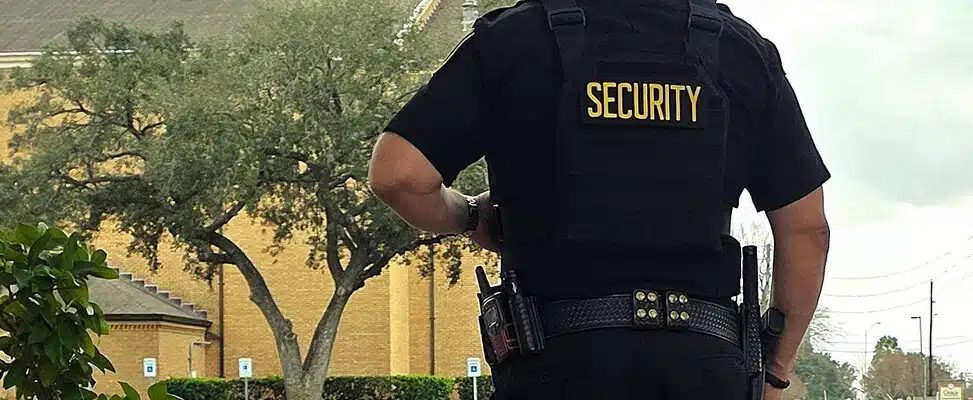 Security guard standing outside a building.